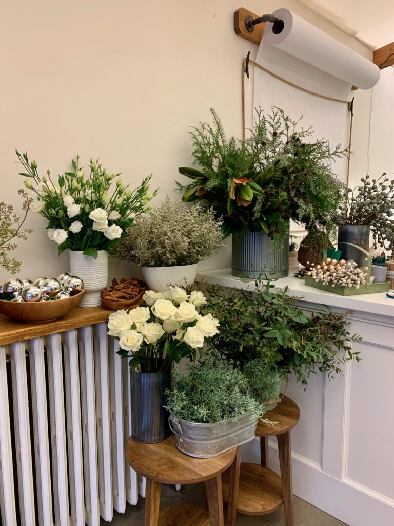 Buckets of flowers and greenery displayed for a holiday floral design class